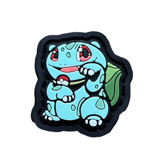 Bulbasaur in the neko (lucky cat) pose. Wearing a poke ball necklace and smiling.