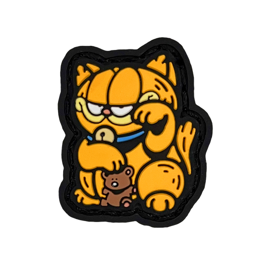 Garfield striking a 'lucky cat' (neko) pose for good fortune. He is holding a teddy bear.